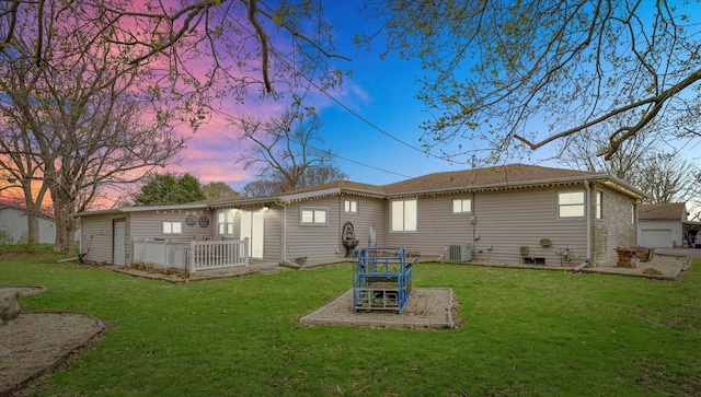 back of property at dusk featuring a lawn
