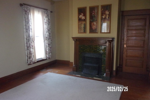 living room featuring a fireplace, wood finished floors, and baseboards