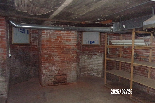 unfinished basement featuring brick wall