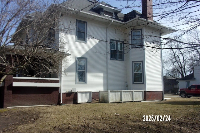 rear view of property featuring a yard and a chimney