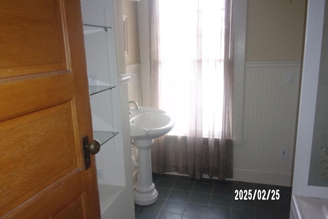 bathroom with a wainscoted wall and tile patterned floors