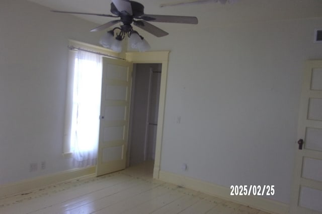 spare room with ceiling fan, light wood-style floors, visible vents, and baseboards