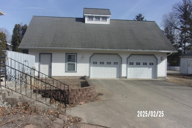 view of front of property featuring a garage and roof with shingles