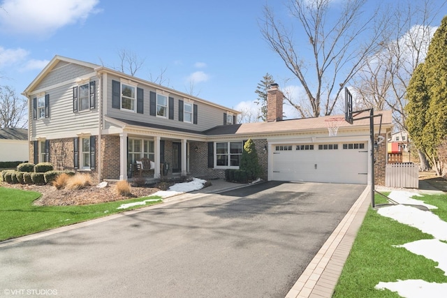 view of front facade with a porch, an attached garage, brick siding, driveway, and a chimney