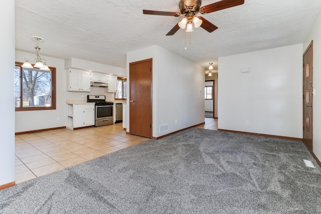 unfurnished living room featuring light tile patterned floors, visible vents, light carpet, a textured ceiling, and ceiling fan with notable chandelier