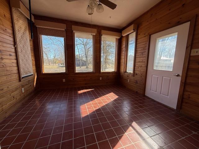 unfurnished sunroom featuring ceiling fan