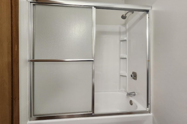 bathroom with bath / shower combo with glass door