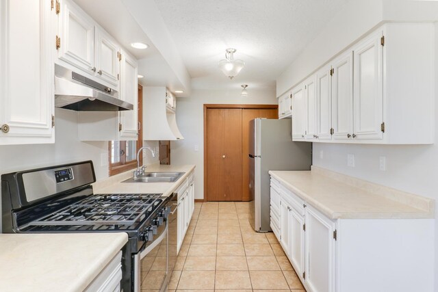 kitchen featuring appliances with stainless steel finishes, white cabinets, a sink, and under cabinet range hood