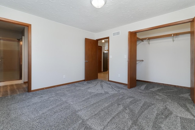 unfurnished bedroom featuring carpet floors, baseboards, visible vents, and a textured ceiling