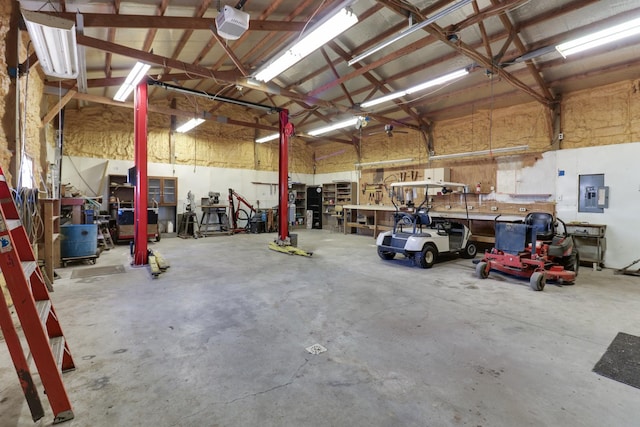 garage with a workshop area, electric panel, and a garage door opener