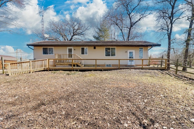 back of property featuring a wooden deck and fence