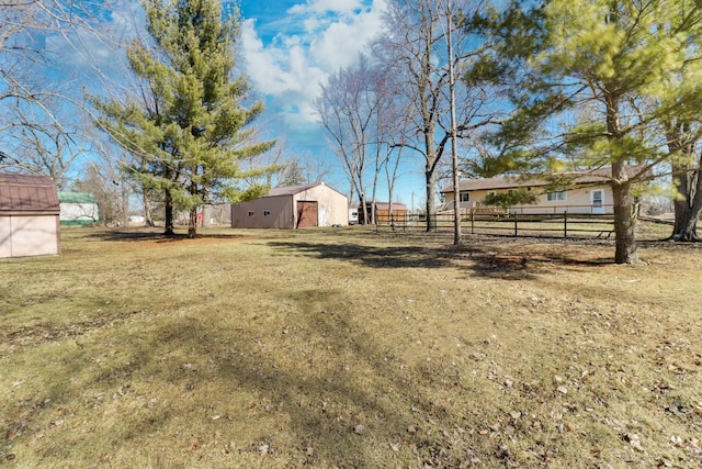 view of yard with an outbuilding and fence