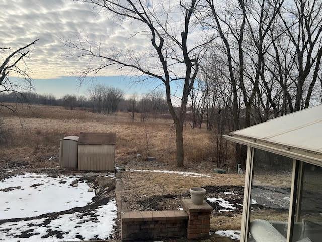 snowy yard featuring a shed