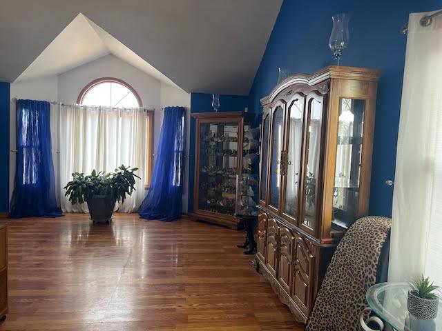 sitting room with dark wood-style floors and vaulted ceiling