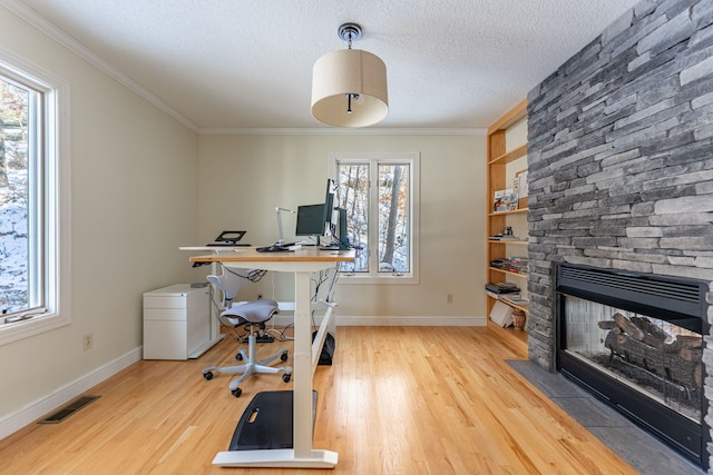 office area with ornamental molding, visible vents, a textured ceiling, and light wood finished floors