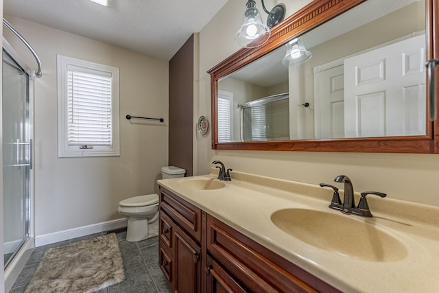 full bathroom with double vanity, a stall shower, a sink, and toilet