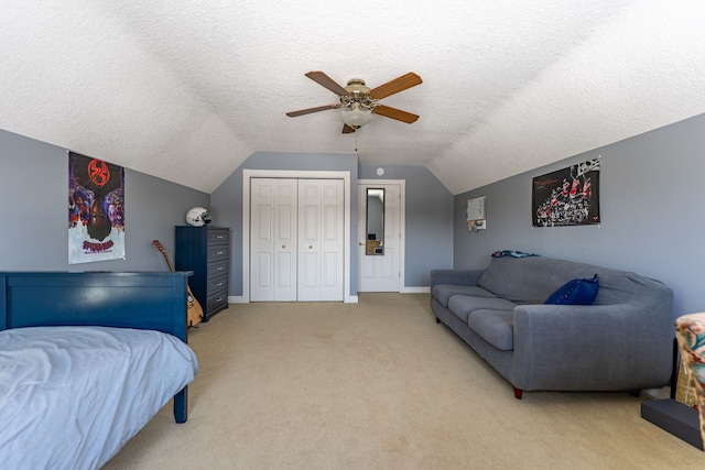 bedroom featuring a textured ceiling, lofted ceiling, light carpet, a ceiling fan, and a closet