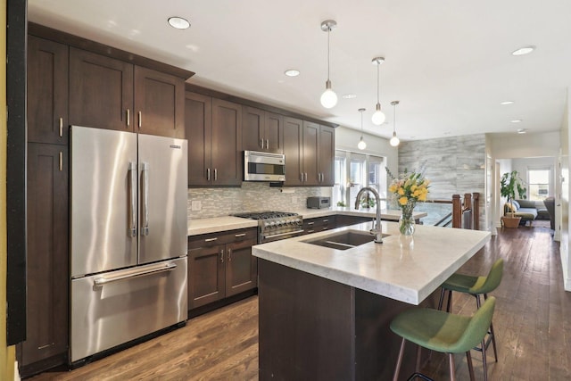 kitchen with stainless steel appliances, plenty of natural light, a sink, and dark brown cabinetry