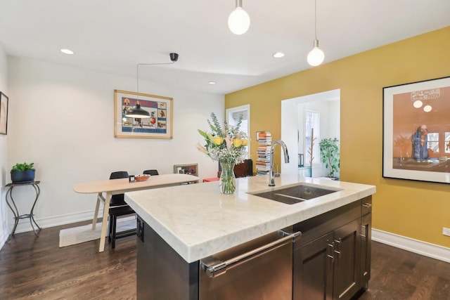 kitchen featuring hanging light fixtures, baseboards, dark wood-type flooring, and a sink