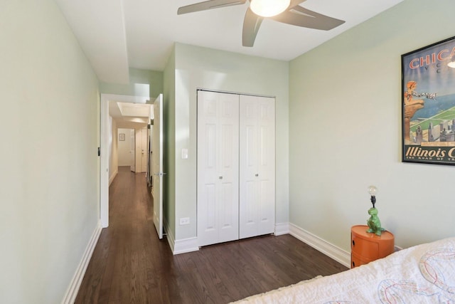 bedroom featuring ceiling fan, a closet, wood finished floors, and baseboards