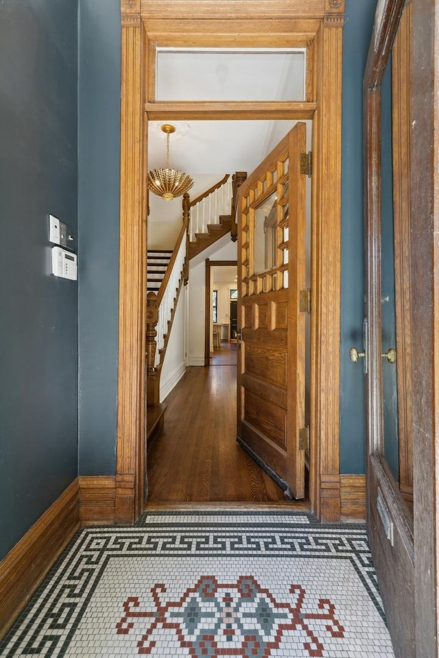 interior space featuring tile patterned floors, stairway, and baseboards