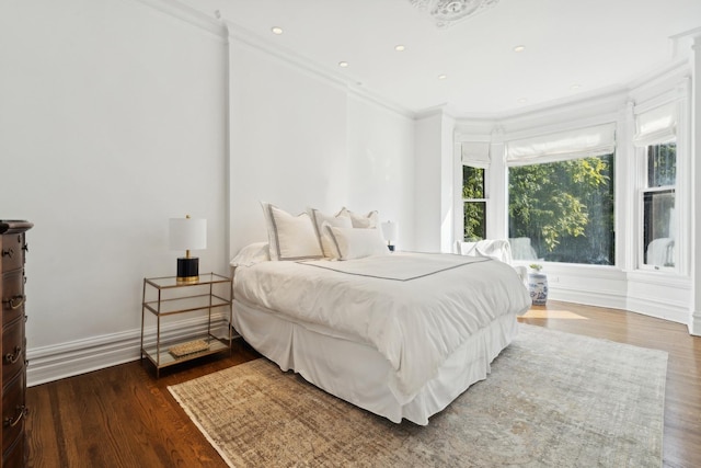 bedroom featuring recessed lighting, baseboards, wood finished floors, and crown molding