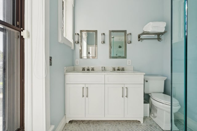 bathroom featuring double vanity, tile patterned floors, toilet, and a sink