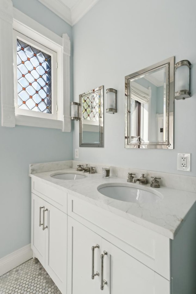 full bath with a sink, double vanity, crown molding, and tile patterned flooring