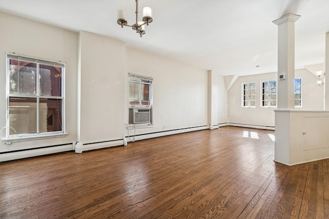 unfurnished living room featuring a baseboard heating unit, decorative columns, hardwood / wood-style floors, cooling unit, and a notable chandelier