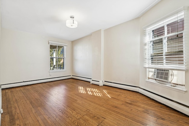 empty room featuring hardwood / wood-style floors, cooling unit, and baseboard heating