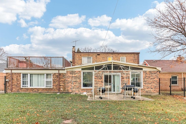 back of property with a patio area, fence, a lawn, and brick siding