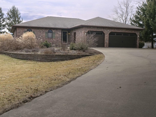 ranch-style home with a garage, concrete driveway, brick siding, and roof with shingles