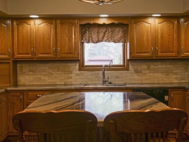 kitchen with backsplash, a sink, and brown cabinets