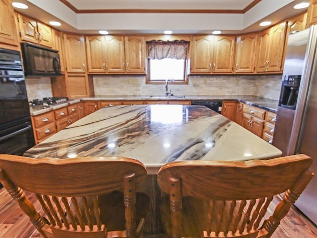 kitchen featuring black appliances, ornamental molding, and backsplash