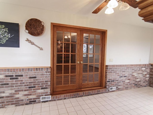 entrance to property with french doors, visible vents, and a ceiling fan