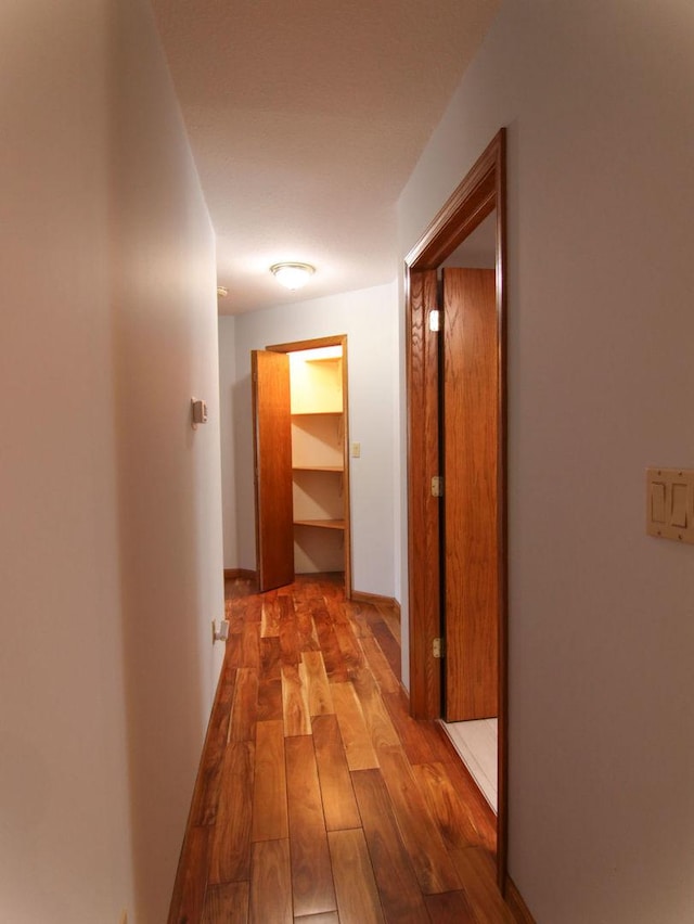 corridor with hardwood / wood-style floors