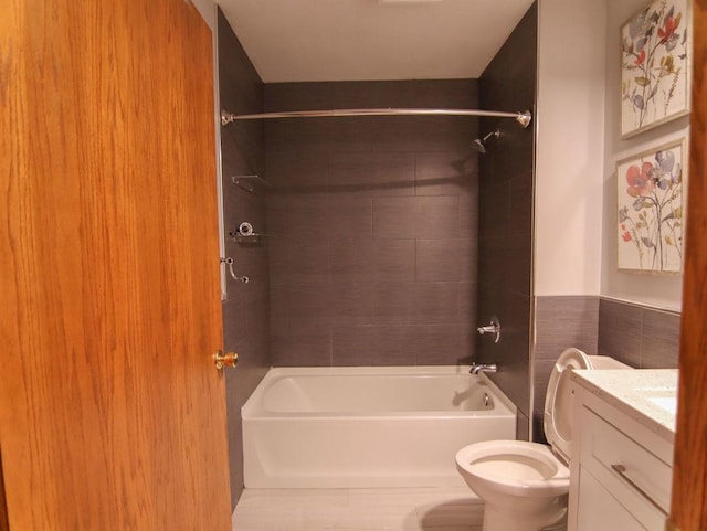 bathroom featuring toilet, shower / bathing tub combination, tile walls, and vanity