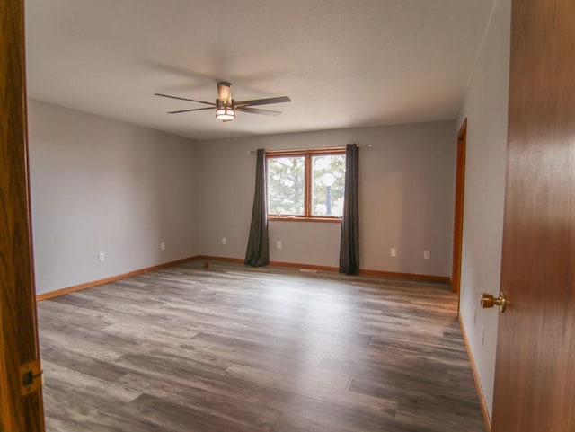 unfurnished room featuring a ceiling fan, baseboards, and wood finished floors