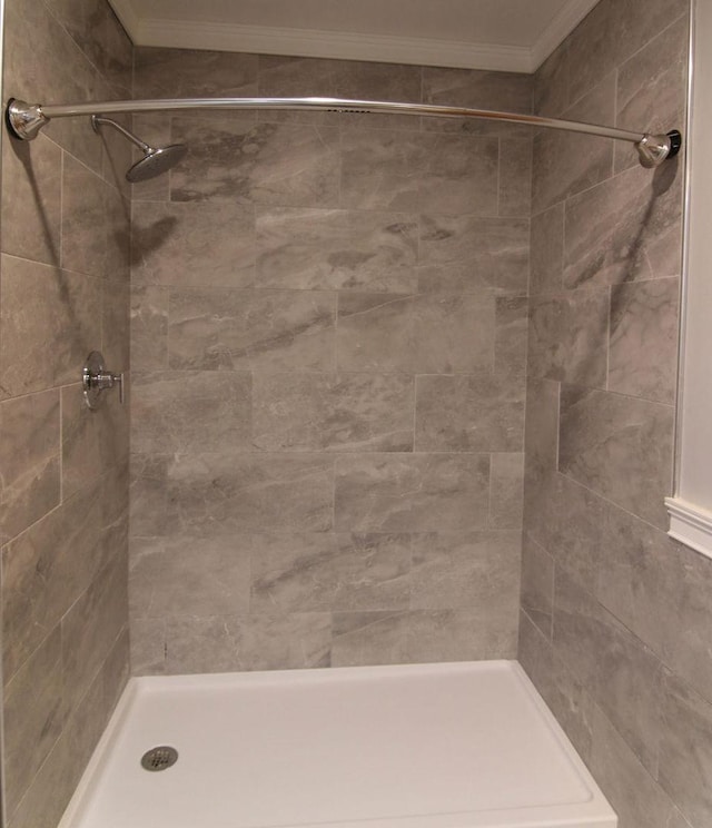 full bathroom featuring ornamental molding and a shower