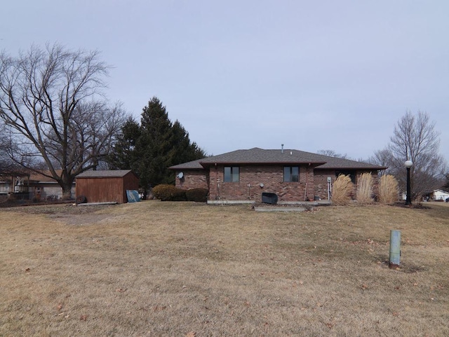 exterior space featuring an outbuilding, brick siding, a yard, and a storage unit