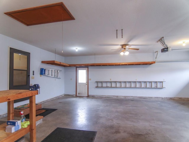 garage with a garage door opener, ceiling fan, and baseboards