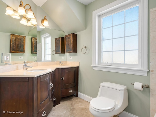 bathroom featuring double vanity, baseboards, toilet, and a sink