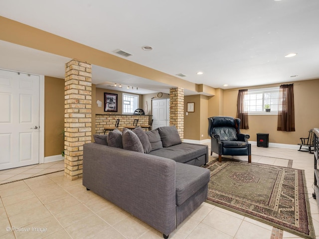 living room featuring visible vents, decorative columns, baseboards, and light tile patterned flooring