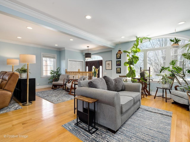 living room featuring ornamental molding, light wood finished floors, recessed lighting, and baseboards