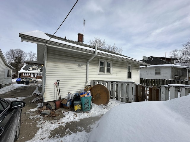 snow covered house with a chimney