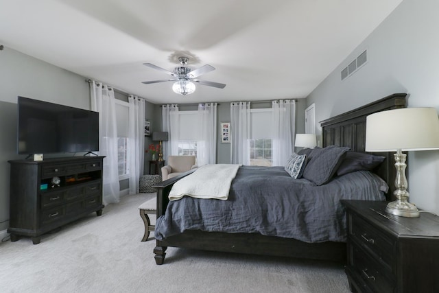 bedroom featuring ceiling fan, visible vents, and light colored carpet