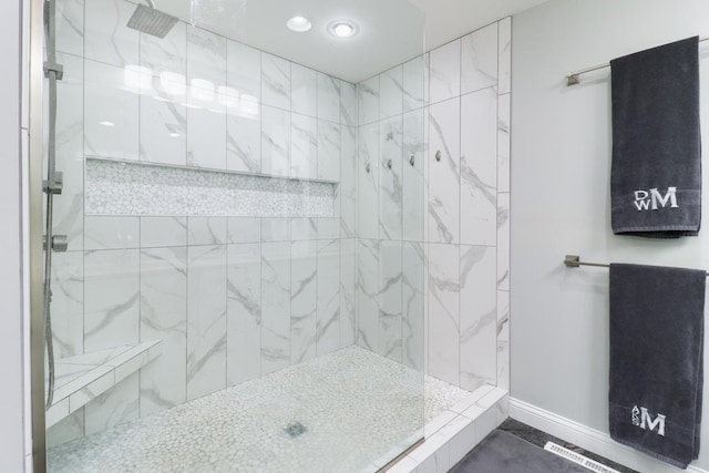 full bathroom featuring a marble finish shower and baseboards