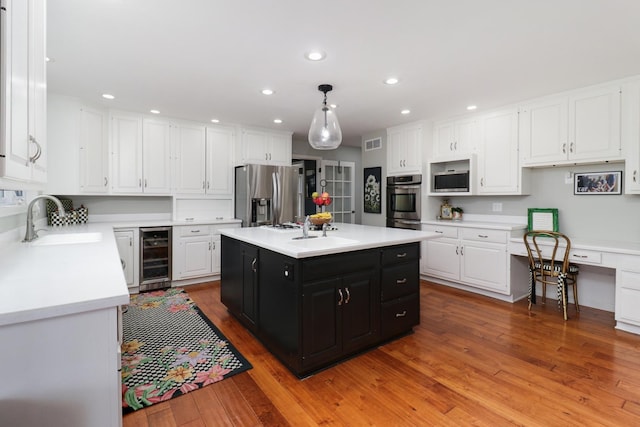 kitchen featuring beverage cooler, dark cabinets, stainless steel appliances, white cabinetry, and a sink