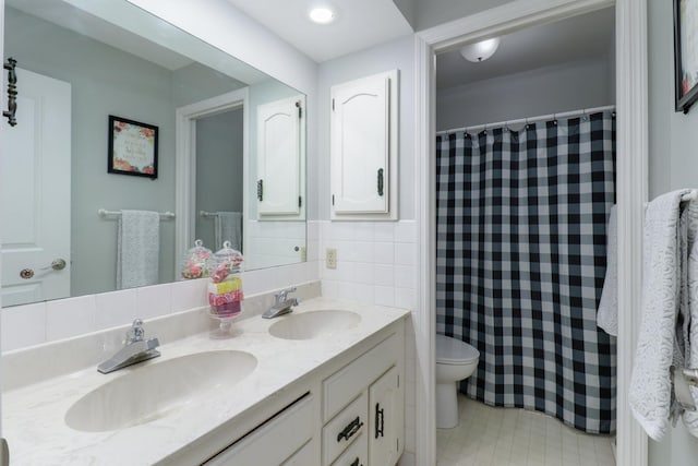 full bathroom featuring double vanity, a shower with shower curtain, a sink, and toilet