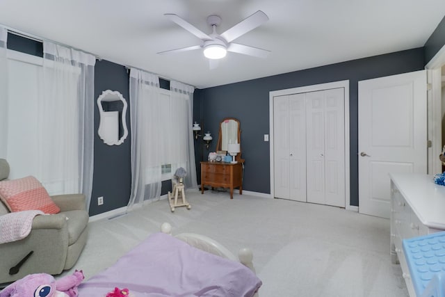 interior space with baseboards, ceiling fan, and light colored carpet